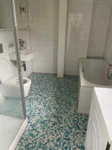 a bathroom with a toilet and a tub and a sink at Your exclusive holiday home in Winterthur