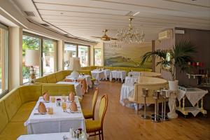 un ristorante con tavoli e sedie e un lampadario di Hotel Nocturnes a Naturno