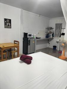 a room with a kitchen with a refrigerator and a table at Lanta Rabbit Rooms in Ko Lanta