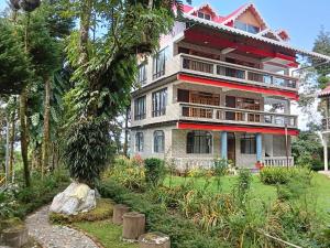 a large building in the middle of a garden at Bloomfield Farmhouse 2 in Darjeeling