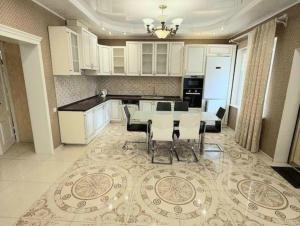 una cocina con mesa y sillas sobre una alfombra en Villa for Life, en Kiev