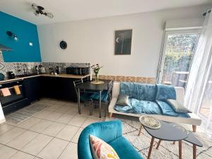 a living room with a couch and a table at Le Faure - Appartement Centre ville et Jardin 2 personnes in Valence +5 photos