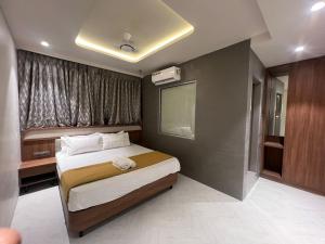 a small bedroom with a bed and a window at Hotel Mood Premium By Glitz Hotels in Vasai