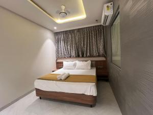 a bedroom with a bed and a window at Hotel Mood Premium By Glitz Hotels in Vasai