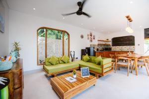 a living room with a couch and a table at Bukti Garden Villas in Bukti
