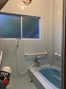a bathroom with a bath tub and a window at 二段ベッドの宿青と白 in Aki +10 photos