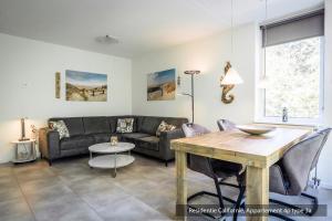 a living room with a couch and a table at Residentie Californië in De Koog