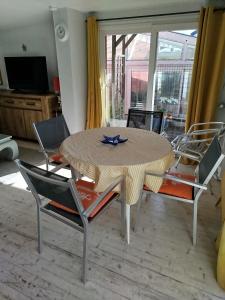 a dining room with a table and four chairs at Face à la mer in Châtelaillon-Plage