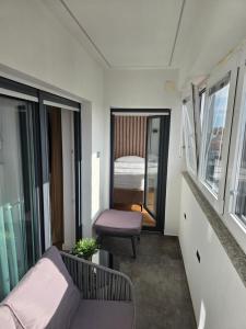 ein kleines Wohnzimmer mit Sofa und Stuhl in der Unterkunft Osijek LUXURY Center Apartment - self check in, 2 parking spaces, balcony, elevator in Osijek