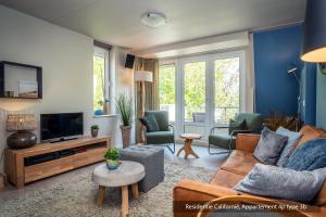 a living room with a couch and a tv at Residentie Californië in De Koog