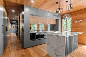a kitchen with gray cabinets and a marble counter top at Tranquill 4BR Retreat in Sassafras