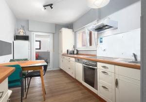 eine Küche mit weißen Schränken und einem Holztisch in der Unterkunft Villa Filimena - Monteurunterkunft Gründau in Gründau