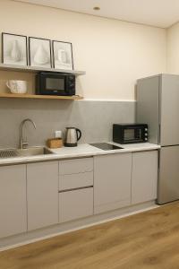 een keuken met een spoelbak en een magnetron bij ЖК Атамура in Promyshlennyy