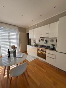 a kitchen with white cabinets and a table and a dining room at Il Canneto in Lomnago