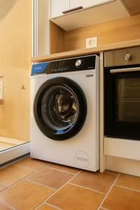 a washer and dryer sitting in a kitchen at Le Nily Provence, douceur & vue d'exception in Sainte-Tulle
