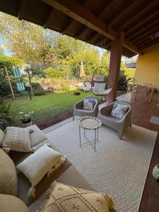 a patio with couches and chairs and a table at Il Canneto in Lomnago