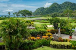 Blick auf einen Park mit Blumen und Bäumen in der Unterkunft Del Mar 3i 3 bdr Ocean View in Los Suenos in Herradura
