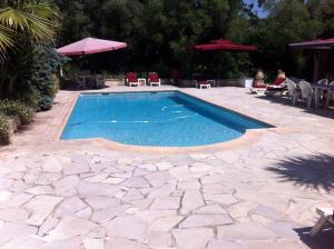 a swimming pool in a patio with chairs and umbrellas at Villa l'Air du temps in Juan-les-Pins
