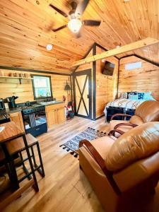 a living room with a ceiling fan and a couch at Adventurer's Nook in High Falls