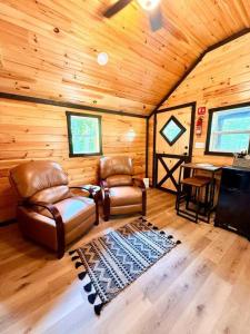 a living room with two chairs and a table in a cabin at Adventurer's Nook in High Falls
