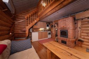 a kitchen and a living room with a brick fireplace at Lakeside cabin, Lake Saimaa in Savitaipale