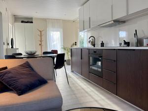 a kitchen with a couch and a table in a room at Ljungskile modern country lodge in Grötån