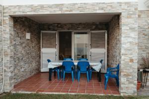 een patio met een tafel en blauwe stoelen bij Casa Chafarinas in Vera