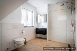 a bathroom with a toilet and a sink at Bungalowpark 't Hoogelandt in De Koog +33 photos