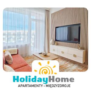 un salon avec une télévision et un canapé dans l'établissement HolidayHomePL Bel Mare F540 z balkonem, à Międzyzdroje