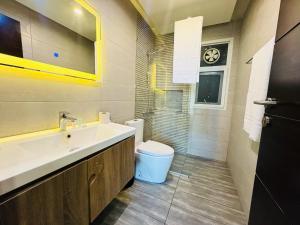 een badkamer met wastafel en toilet bij Executive Prestige Hotel Apartments Facing Centautus - Elysium Tower Islamabad in Islamabad +35 foto's