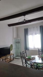 a living room with a table and chairs and a couch at Stéphanie in Remoulins +17 photos