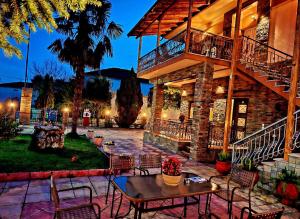 a patio with a table and chairs in front of a building at Petroula Suites Pozar in Kato Loutraki