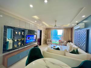 een woonkamer met een bank en een tv bij Executive Prestige Hotel Apartments Facing Centautus - Elysium Tower Islamabad in Islamabad