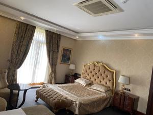 a bedroom with a large bed and a window at Lake view Palace Hotel in Baku