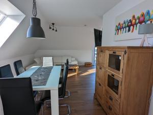 une salle à manger avec une table, des chaises et un canapé dans l'établissement Moderne Landhaus-Ferienwohnung mit Balkon, à Kempen