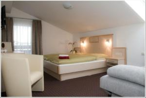 a bedroom with a large bed and a couch at Pension Dorfplatzl in Fusch an der Glocknerstraße