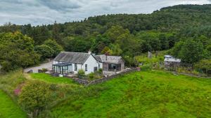 une vue aérienne d'une maison dans un champ dans l'établissement Blair Cottage, à Rowardennan
