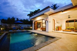 a villa with a swimming pool at night at Bukti Garden Villas in Bukti