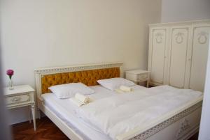 a large white bed with two white towels on it at Contessa Apartment Cluj Napoca in Cluj-Napoca