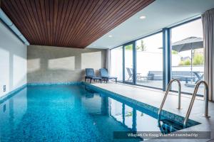 a swimming pool with blue water in a house at Villapark De Koog in De Koog