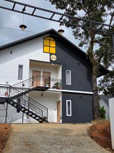 uma casa preta e branca com uma janela amarela em The Tea Leaf Munnar em Anachal