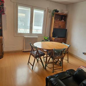 Una sala de estar con una mesa y sillas de madera. en Casa Rural "AMARA" Bardenas, en Valtierra