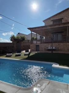 a swimming pool in front of a house at Los Olivos de José in El Barraco