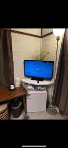a tv on a shelf with a table and a lamp at One room Pusang Gala Yuki City in Yuki