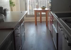 eine Küche mit einem Tisch und Holzböden in der Unterkunft Chambre cosy à Caen centre in Caen