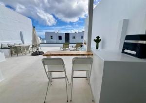 a kitchen with chairs and a table on a balcony at casamujeres in Punta de Mujeres