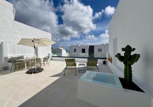 a patio with a table and chairs and a cactus at casamujeres in Punta de Mujeres