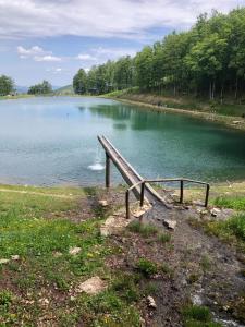 a view of a large lake with a wooden railing at Il Seccatoio in Riolunato +17 photos