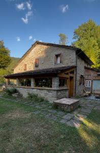 an old stone house with a bench in front of it at Il Seccatoio in Riolunato