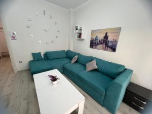 Una sala de estar con un sofá verde y una mesa. en Serres city center modern apartment (Monika), en Serres